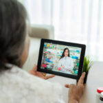 A woman talking to a doctor on a tablet